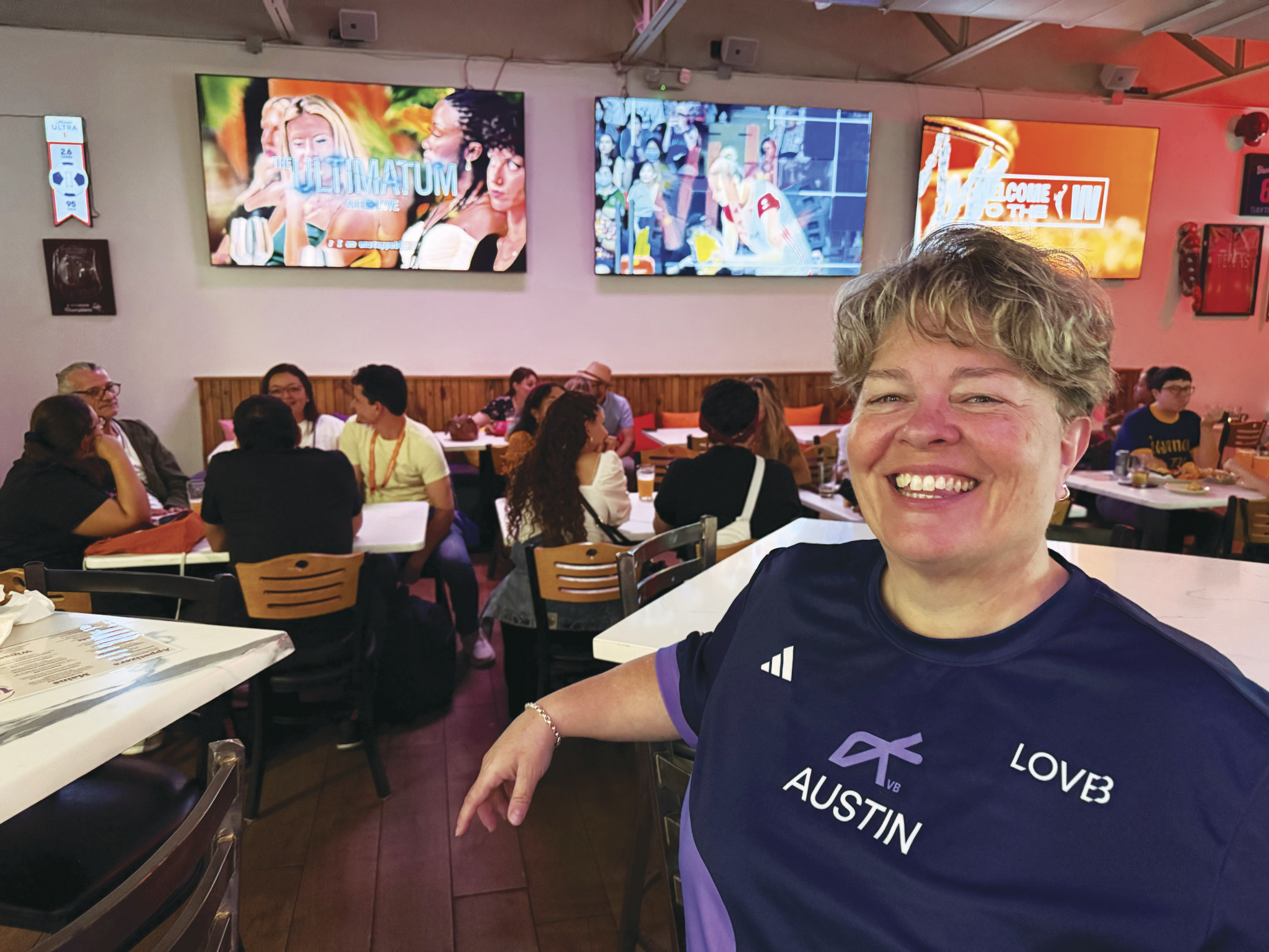 Owner of 1972 sports pub poses in front of the bar. 