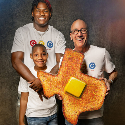 Colin Simmons, his brother Clay, and Artist Ken Womack, who is holding a giant slice of toast art.