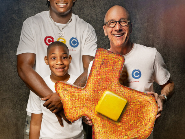Colin Simmons, his brother Clay, and Artist Ken Womack, who is holding a giant slice of toast art.
