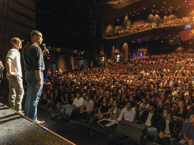 Actors speak to audience of students.
