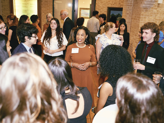 Kea surrounded by scholarship students at the Etter-Harbin Alumni Center.