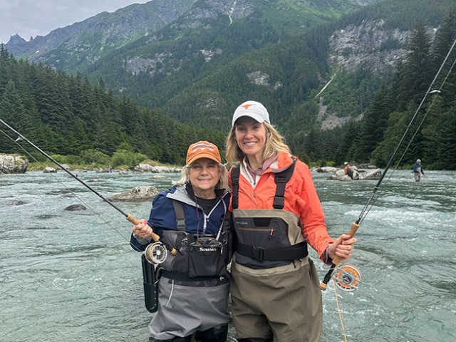 Two Longhorn alumnae fishing in Alaska river.