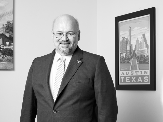 A headshot of a smiling man in a suit.
