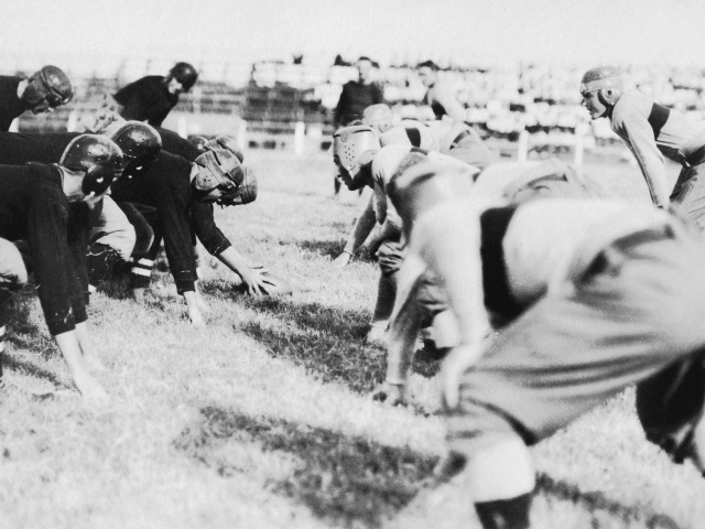 An archival photo of football players at the line, 1914.