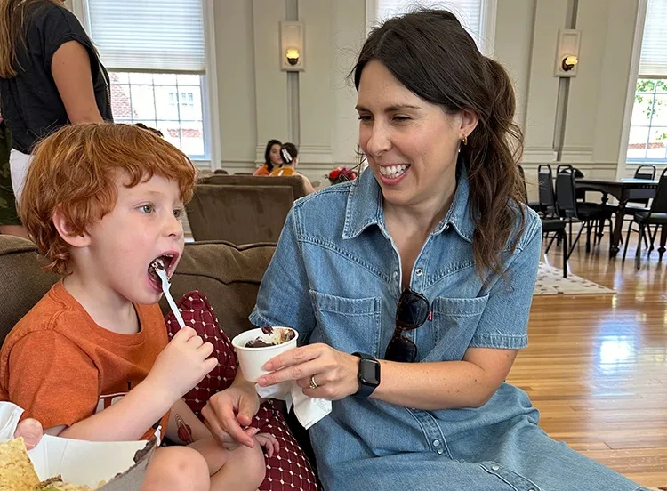 A kid eating dessert along with a friend