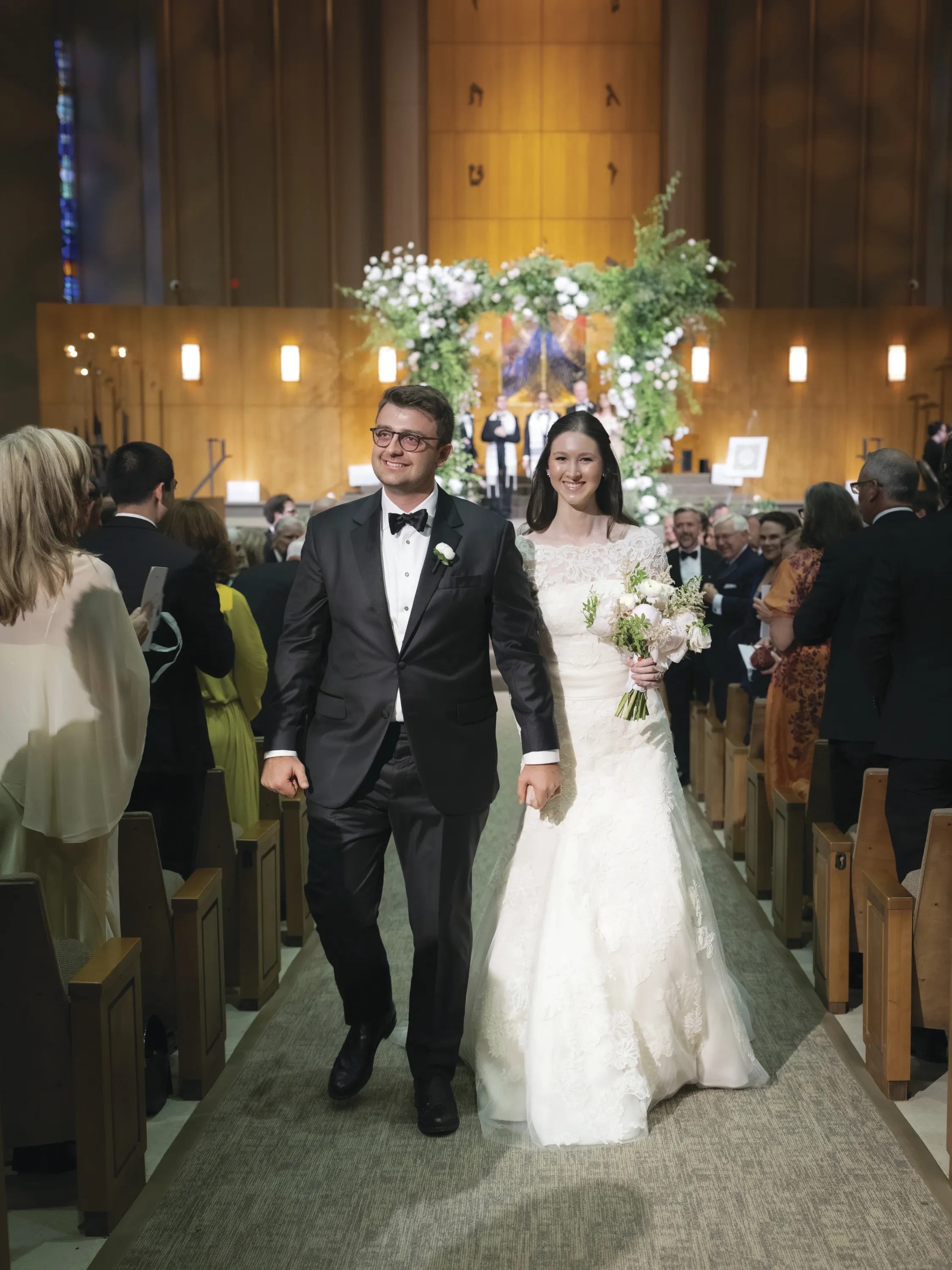 A couple walks down the aisle toward the camera.