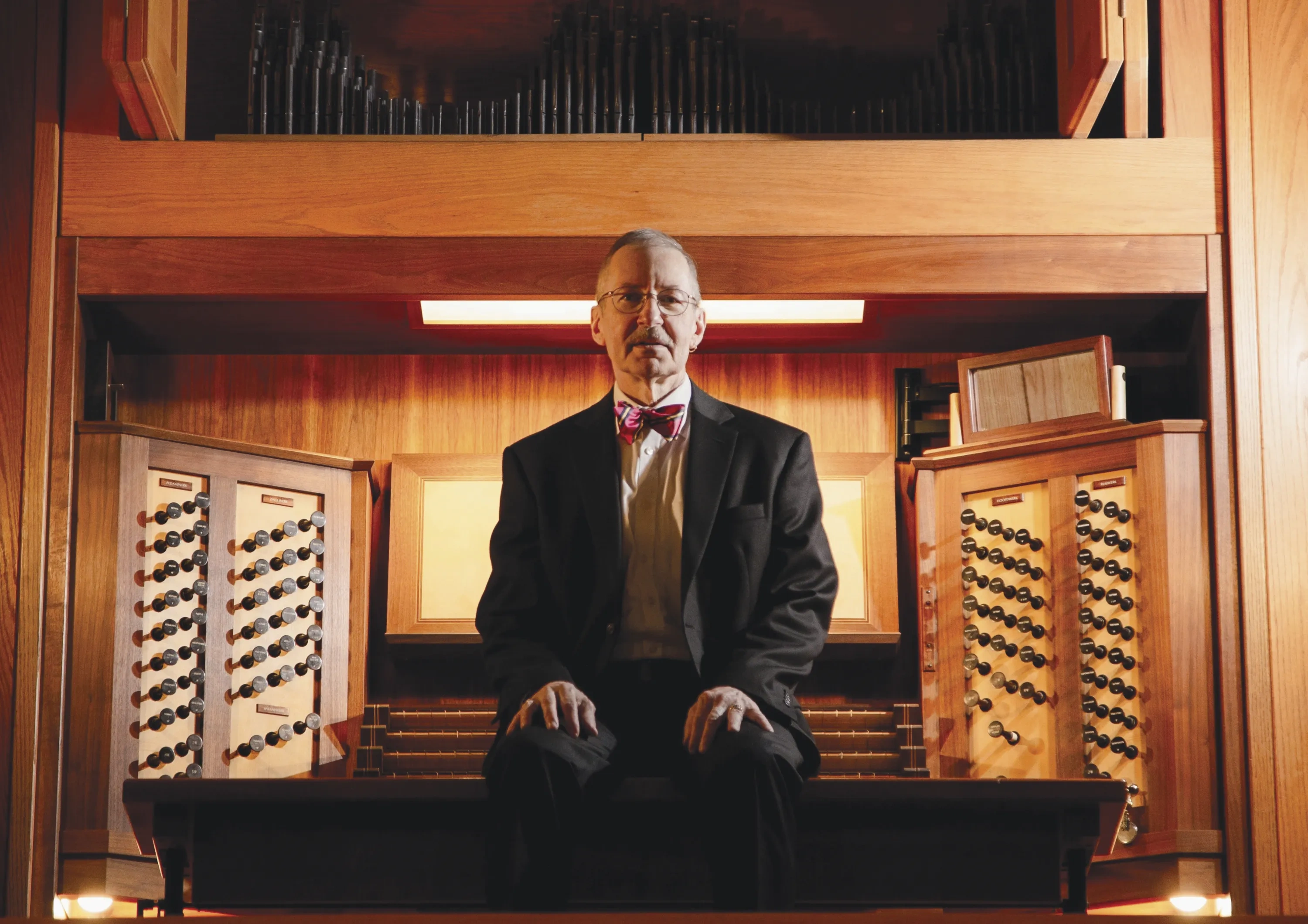 Gregory Eaton sitting in front a pipe organ
