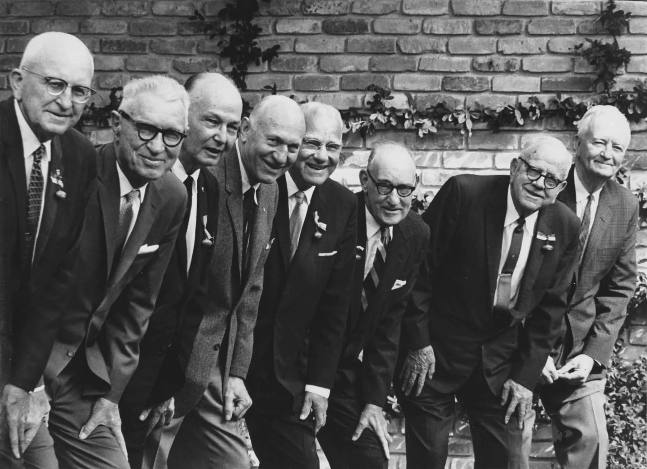 A group of old men lined up in suits.