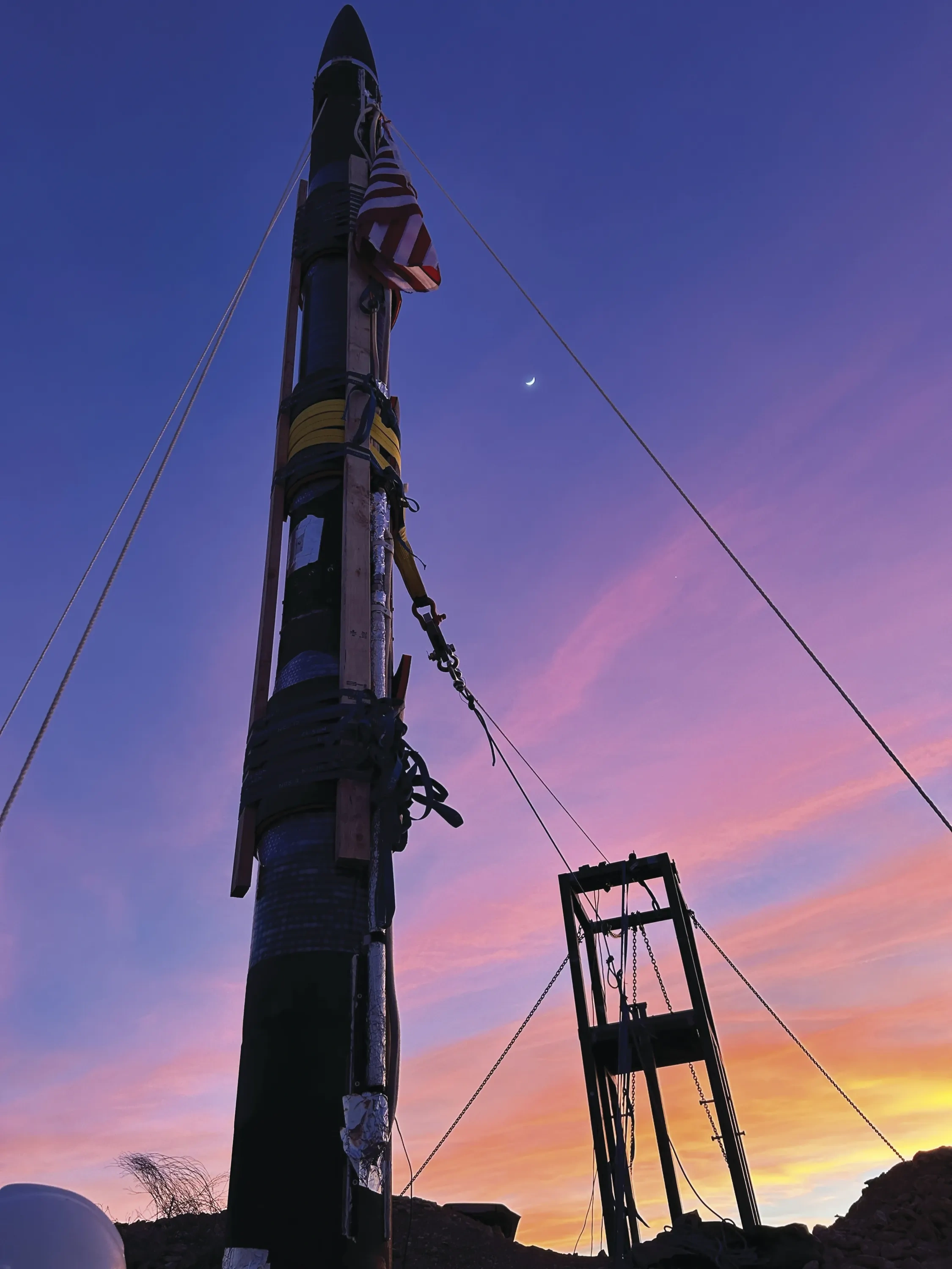 The Halcyon rocket stands tall as the sun sets behind it.