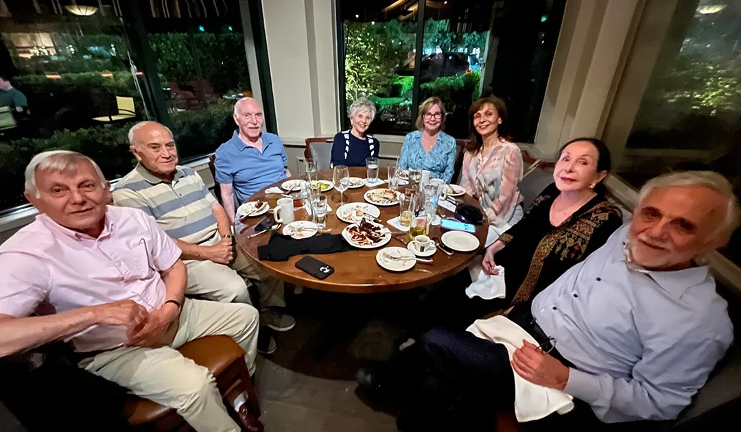 A group of friends sit around the table for dinner
