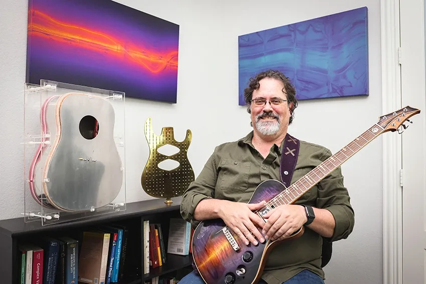 Russell Stoneback with this artwork and a few guitars.