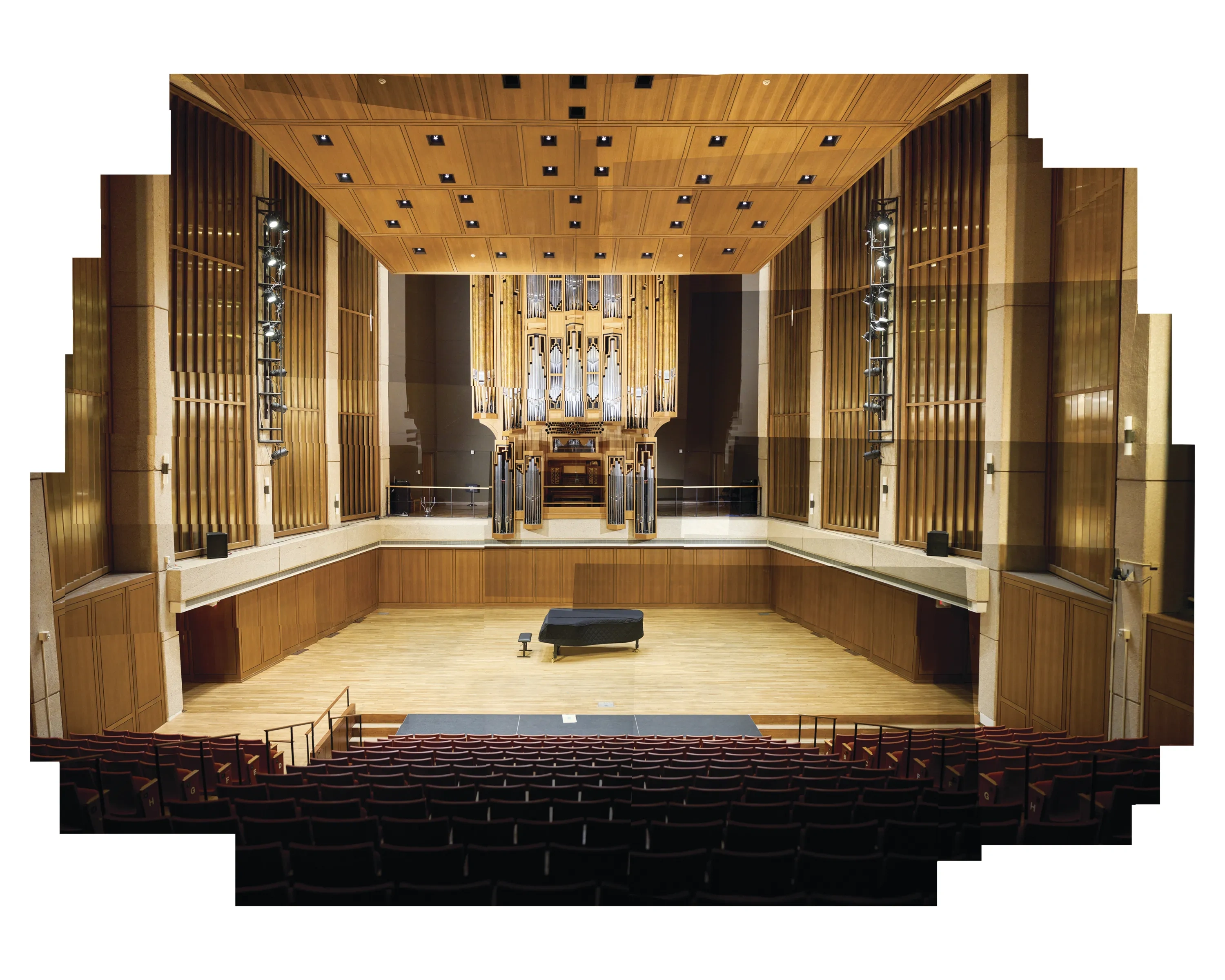 A wide shot of a recital hall with a large organ.