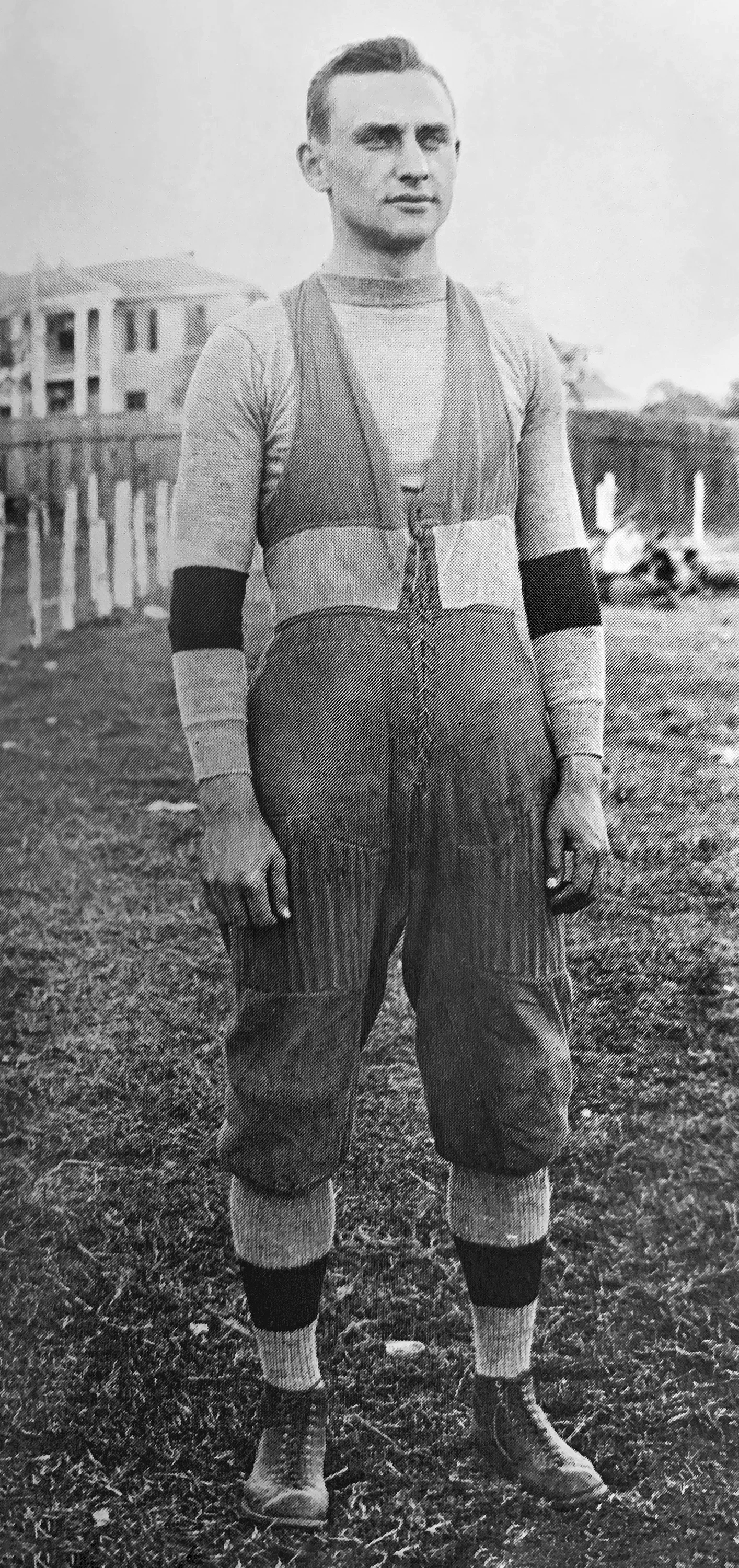 An archival photo of a man in a 1900s football uniform.